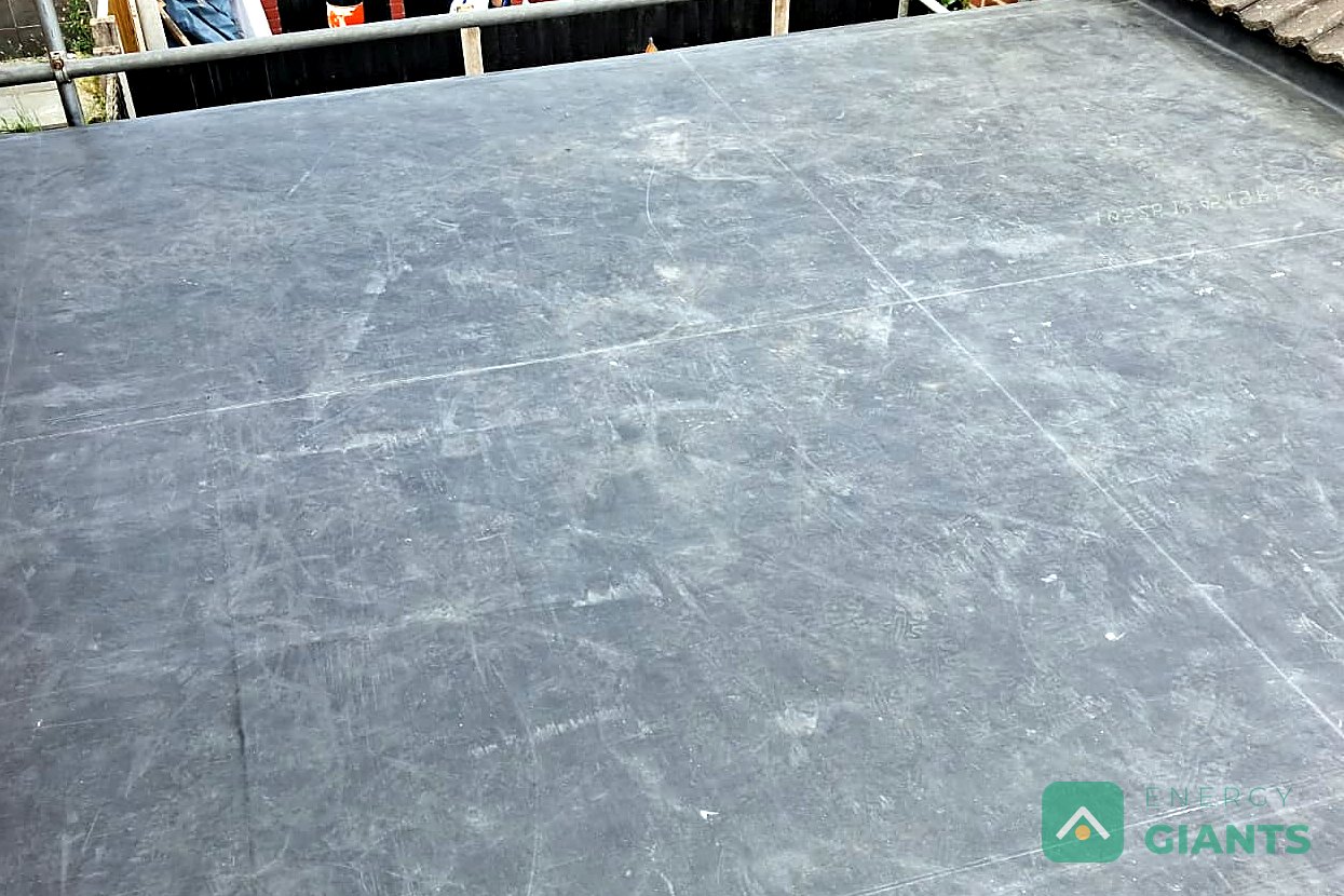 The finished EPDM warm roof over a rear extension in Litherland, seen from the scaffold beside the tiled main roof