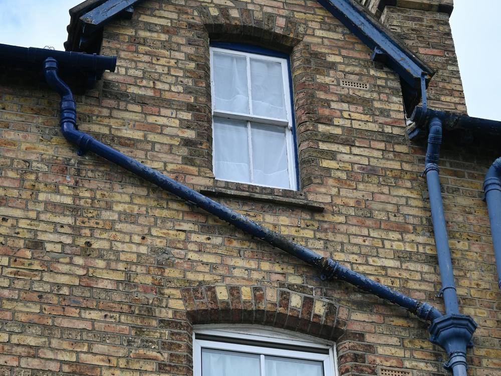 A British brick house with dark gutters and downpipes