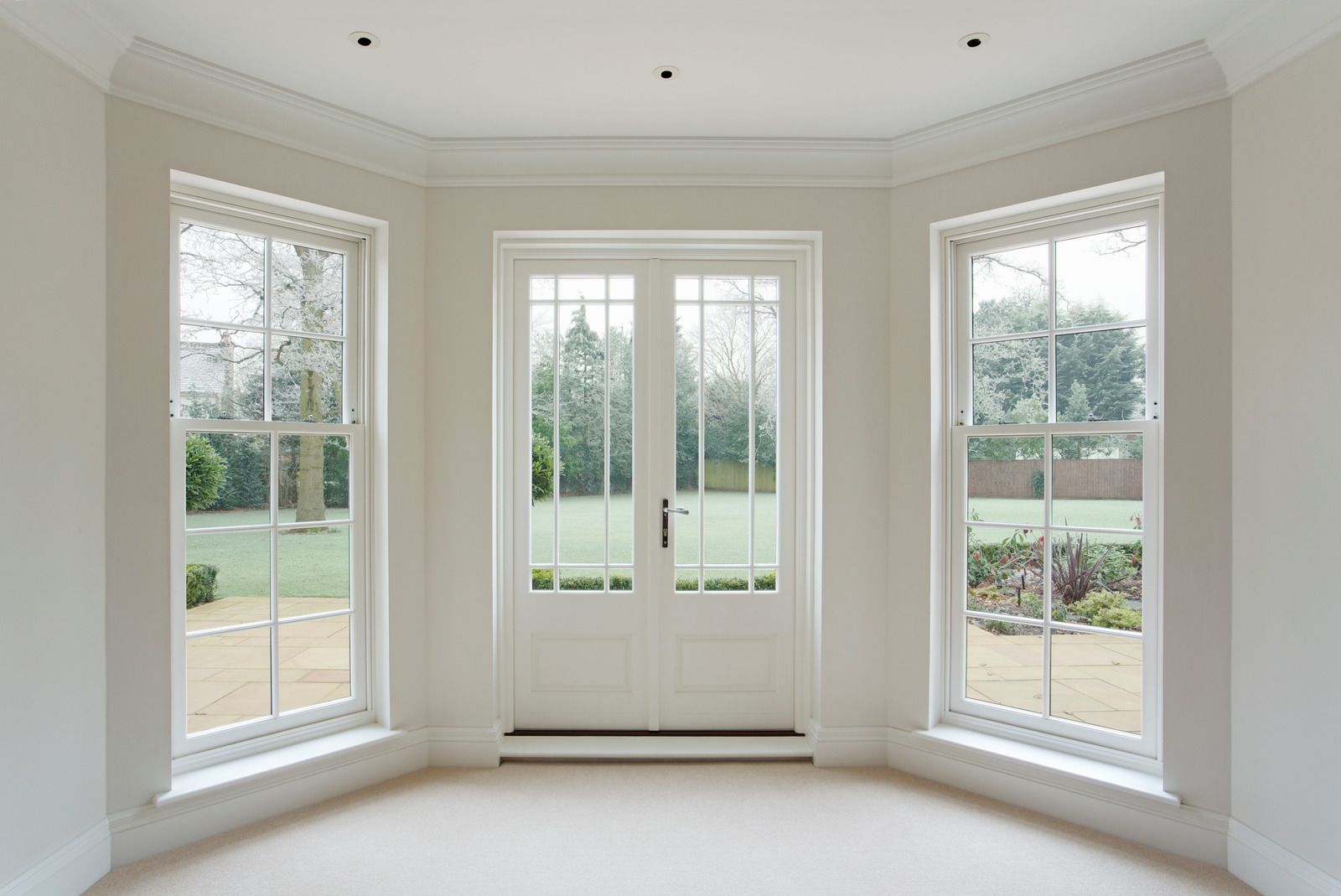 A bright bay with white sash windows and French doors. Illustrative image
