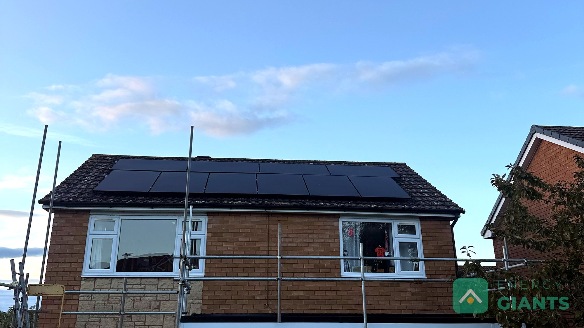 A brick semi detached house with its garage flat roof newly rebuilt as a warm roof, finished in black EPDM with white fascias