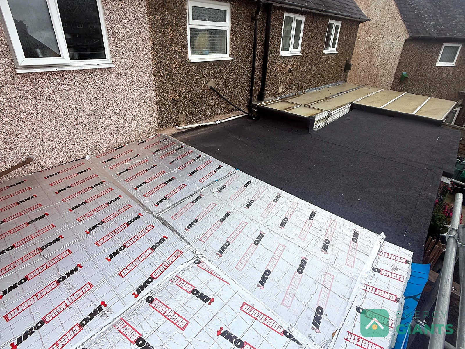 Foil faced PIR insulation boards laid across a flat roof in Llanrwst