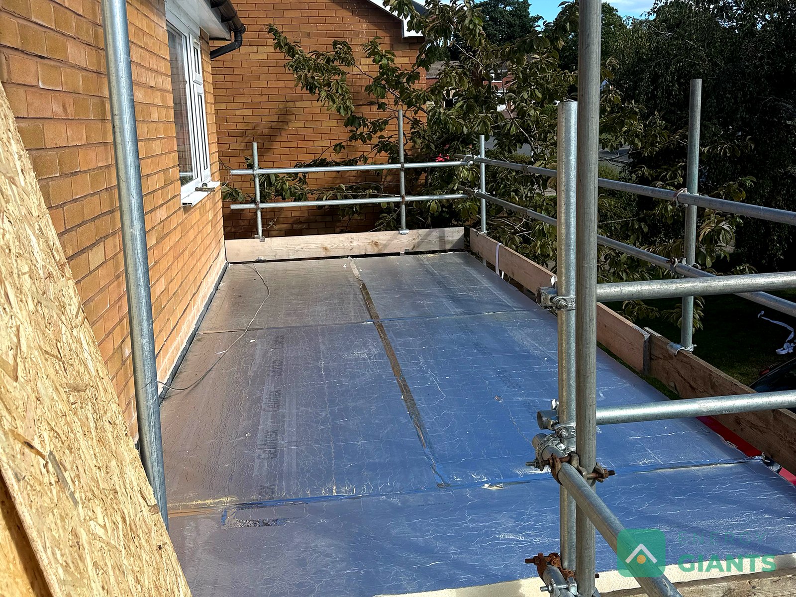 Foil faced PIR insulation boards laid across a flat roof in Ruthin